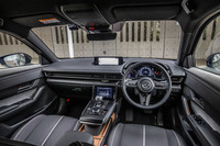 水平基調のインストゥルメントパネルやステアリングホイールなどのデザインは従来型の「MX-30」に準じたもの。メーターや液晶ディスプレイに「ロータリーEV」専用の表示項目が追加される以外に大きな変更はない。