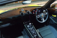 「718ボクスターT」のコックピット。グロスブラック仕上げのインストゥルメントパネルや「Boxster T」のロゴが入ったメーター、360mm径のモードスイッチ付き「GTスポーツステアリングホイール」などが標準で装備されている。