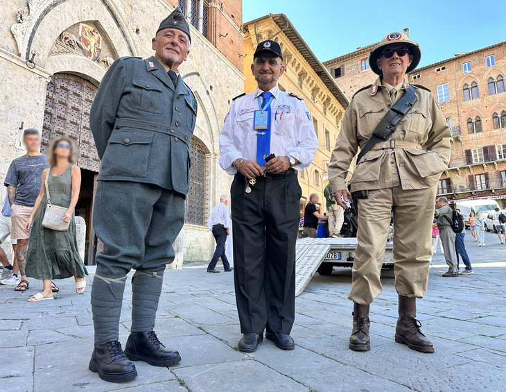 カラビニエリ車両コレクターのミーノ・マリーノ・ファラッリ氏(中央)。写真向かって左は王国カラビニエリ時代の制服、同右は旧アフリカ戦線の制服に身を包んだ協会員。