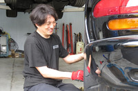 左リアのタイヤを装着する本多氏。「大径タイヤの交換ってホント大変なんですよ。ウチの機材だと30インチまで脱着できるけど、正直、1本1万円くらいもらわないとやりたくないですね(笑)」