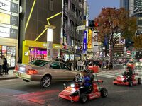 渋谷109前の交差点で。ひと月前のニュースで話題となった事故車と同じく、ハイドロ機構をもったローライダーと、外国人観光客が運転するカート。