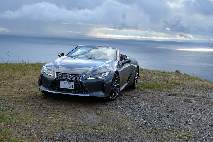 雨上がりの晴れ間に海辺を臨める高台で。陽光を受けて輝くのは「レクサスLC500コンバーチブル」だ。
