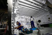 「787」の中央翼に艤装(ぎそう)を施す工程の様子。自動車の製造工程と比べて人の手による作業が非常に多い。