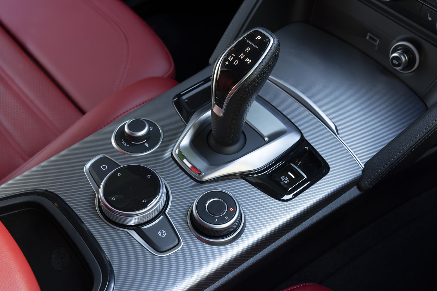 シフトセレクター周辺には、インフォテインメントシステムのコントローラーや「ALFA DNAドライブモードシステム」のセレクターなどが美しくレイアウトされている。