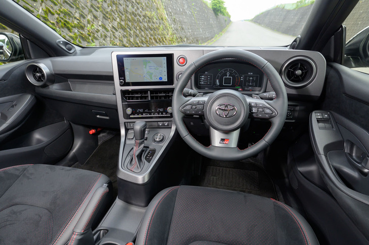 インストゥルメントパネルは普通の「ヤリス」とは別物に進化。シボすらもない樹脂パネルは後付けのようなしつらえだが、スクリーンの位置を下げ、操作系を全体的にドライバーに寄せている。