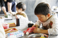 「ディフェンダー」のシルエットに切り抜かれた天然木を使い、木のクルマ「kinocca(キノッカ)」を制作するワークショップは、多くの子供たちでにぎわった。