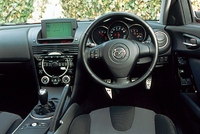 「ストイックな旧来のスポーツカーテイストではなく、“コンフォータブリータイト(心地よい包まれ感)”を基本テーマにした」(プレスインフォメーション)というインテリア。とはいえ、そこはスポーツカーに関して一家言あるマツダのこと。じゅうぶん“スポーツカーテイスト”だ。凝った造形のサイドブレーキが、ちゃんとセンタートンネルの右側についている。