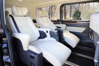 リアの4座は固定式の大型アームレストやサイドまで回り込んだヘッドレスト、さらにはオットマンが備わる「エグゼクティブパワーシート」。2列目(写真)の左右座席間には格納式のテーブルが用意されている。