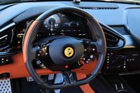 ステアリングリムはカーボン製。スタート/ストップスイッチはホーンパッドの下に備わっており、まずはブレーキを踏まずに押して車両に電気的なチェックを回し、その後にあらためてエンジンをかけるというのが最新フェラーリの始動法である。