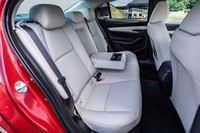 「セダン」のリアシート。ドア形状が異なっているため「ファストバック」に比べて乗り降りはしやすいが、マツダの発表数値によればセダンのショルダールームはファストバックより3mm広いだけで、両車の居住性にほとんど差はない。後席背もたれはセダン、ファストバックとも6:4分割可倒式を採用している。