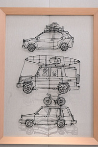 壁に飾られたワイヤーアート、上から「ヤリス」と「ランドクルーザー“70”」、そして「スプリンターカリブ」。