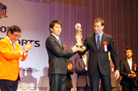 ラルフ・ファーマンと伊藤大輔(写真右)。オレンジ色のジャケットは、副賞「オートバックス賞」を授ける同社の住野公一CEO。「それぞれのモータースポーツ団体が手を取り合うのはいいことだ」と今回の表彰式そのものを称えた。