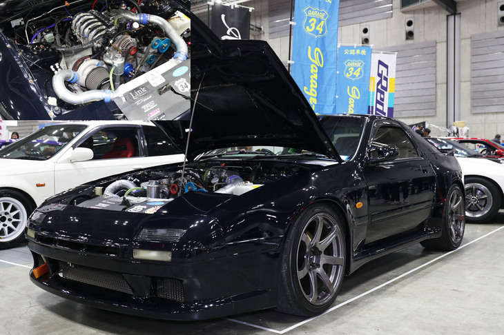 ガレージ34が展示していた「マツダ・サバンナRX-7」(FC3S)。ミッドナイトブルー(濃紺)に塗られた外観はおとなしいが、エンジンは3ローターの20Bターボに換装されていた。
