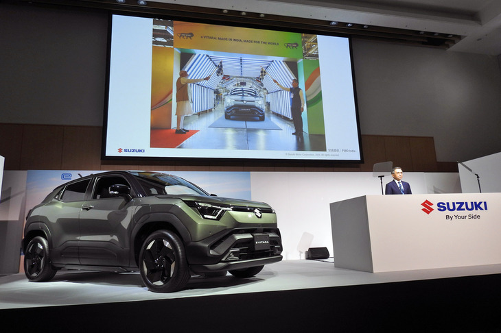 鈴木俊宏社長によるプレゼンテーションの様子。スクリーンに映されているのは、つい先日に催された、印グジャラート工場でのラインオフ式の様子だ。