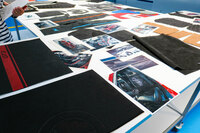 テーブルに並べられたサンプルの数々。「アルファ・ロメオ・トナーレ」や「日産マイクラ」といった比較的身近なクルマから、「マセラティMC20」といったスーパーカーまで、幅広いクルマに「コンプレックスマニュファクチュアリング」の製品は使われている。