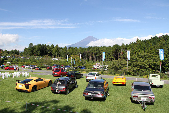 開場前の会場風景。青空に富士山が映える。手前の9台は、50年を振り返ってとくに印象深いクルマを選んだテーマ展示車両の一部。