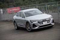 富士スピードウェイの1コーナー先にある「Audi Sport」の看板をバックに。都内から往復した平均電費は4.5km/kWhだった。