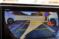 「後退出庫サポート機能」では、バックカメラがクルマの後ろを通る歩行者や他車を認識すると、オレンジの矢印で警告してくれる。