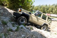 勢いをつけて岩場を乗り越える「ランドクルーザー“70”」。同車には、悪路において自動で一定速走行を行う「クロールコントロール」などの機能は用意されておらず、ドライバーは自らの手足でクルマを操る必要がある。