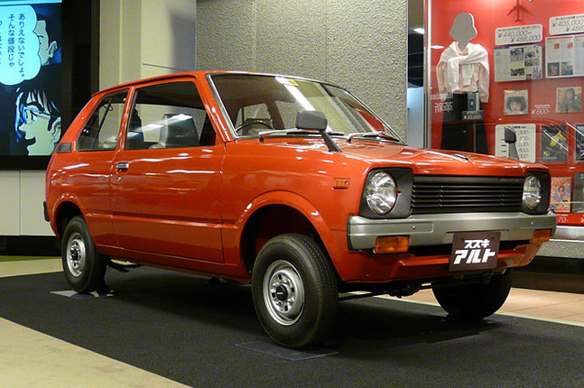 徹底的にコストダウンして47万円という低価格を実現した「アルト」(1979年)。メカニズムも一新され、12年ぶりにRRからFFに戻り、539cc水冷2ストローク3気筒(28ps)エンジンで前輪を駆動する。朱色のボディカラーは、鮮やかな赤より塗料のコストが安かったため採用されたと言われている。