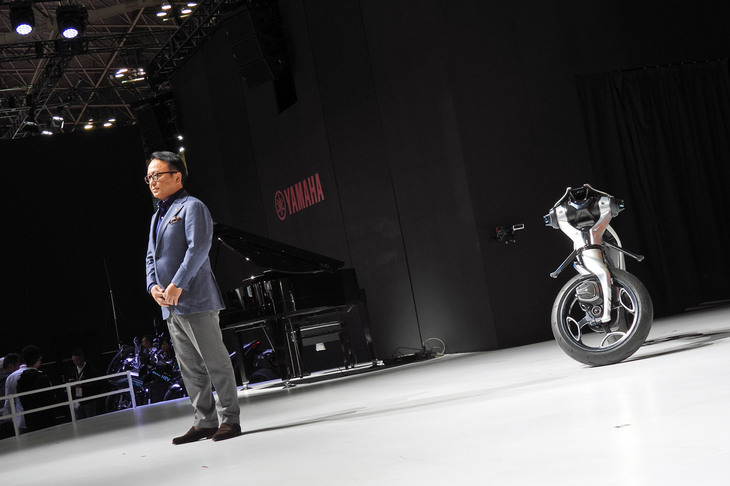ヤマハ発動機の設楽元文社長と、彼の指示に従って自立する「モトロイド:ラムダ」。