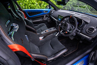 アルミとカーボン、マイクロファイバー表皮でコーディネートされたインテリアは、レーシーな雰囲気。サベルト製のモノコックバケットシートには6点式のレーシングハーネスを装着するためのアダプターが付属している。