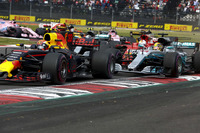 優勝してタイトルを決めたいハミルトン(写真右)だったが、スタート直後に思わぬ不運に見舞われた。ターン2でフェルスタッペン(同左)と接触し3位に落ちたベッテル(同奥)とヒット、ハミルトンのメルセデスはリアタイヤをパンクさせ、フロントウイングを壊したベッテルとともに緊急ピットインを強いられた。最後尾から追い上げて9位入賞、ベッテルとのポイント差を56点とした彼は今季のドライバーズタイトルを獲得した。(Photo=Mercedes)