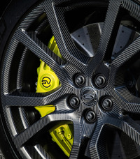 23インチという大径カーボンホイールは、鋳造アルミのものに比べ、1台分で35.6kg軽量。バネ下重量の大幅な軽量化を実現し、動力性能向上に貢献する。その奥に見えるブレンボ製の8ピストンキャリパーにカーボンセラミックローターと、スーパースポーツ並みの装備がおごられている。