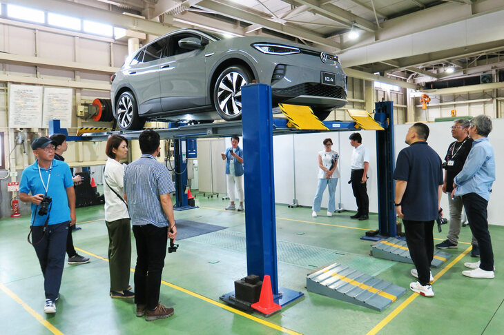 「ID.4」をリフトで持ち上げ、車体底部を観察するイベント参加者。サスペンションのロワアームに風防を設けるなど、徹底した空気抵抗低減の施策がなされていた。