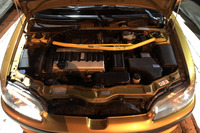 フロントに横置きされる1.6リッター直4 DOHC 16バルブエンジンは最高出力118PS、最大トルク142N・mを発生。写真のOMP製ストラットタワーバーは、標準仕様にはない後から加えられたカスタマイズアイテムだ。