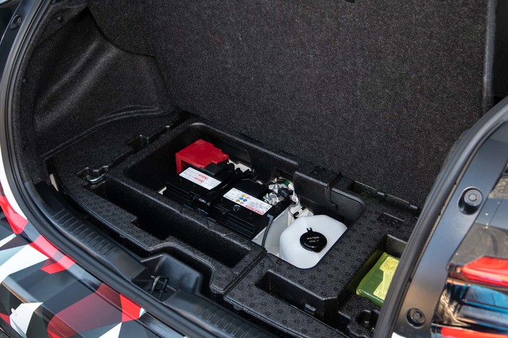 前後重量配分を考慮して12Vバッテリーは荷室の床下に設置される。その隣の白いものは、インタークーラー冷却用のウオータースプレー(オプション)のタンク。