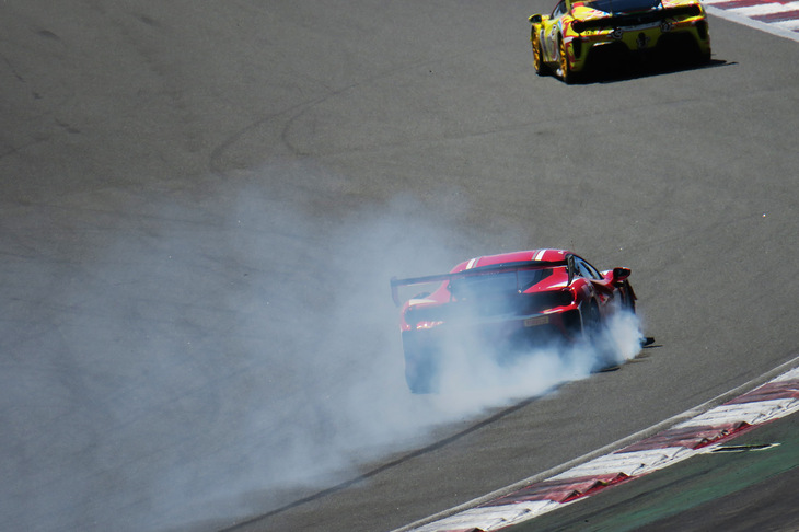 スピンした前走車をフルブレーキとハンドリングでかわしたマシンが、足もとから白煙を吹きながらコーナーを立ち上がっていく。