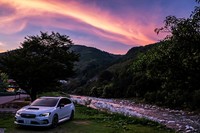 山梨・勝沼で乗り換えた最新の「レヴォーグ」で夕刻、昼神温泉に到着。ここは南信州で最大規模といわれる温泉地で、岐阜県との県境に位置する。阿智川の清流をバックに、美しい夕焼けとともに記念撮影。