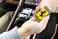 ボンネットエンブレムを思わせるデザインのキーフォブ。センターコンソールのシフトセレクター手前に、固定するためのスペースが設けられている。