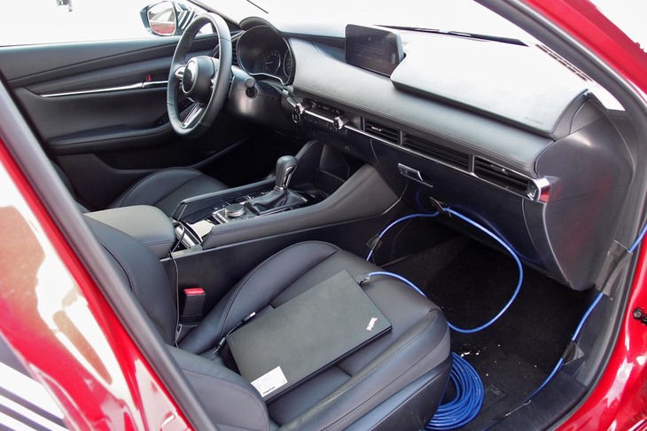 「GVCプラス」のテストは、運転中に助手席の開発スタッフがPC(写真手前)を使って制御のオンオフを切り替える方式で実施。車両の乗り換えをしないおかげで、その効果がより明確に体感できた。なお、量産型の「マツダ3」は全車GVCプラスを標準装備。スイッチなどでオフにすることはできない。