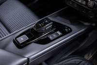 特徴的なブリッジ形状のセンターコンソール上にシフトセレクターやパーキングブレーキ、ドライブモード切り替えスイッチなどが並ぶ。ブリッジの下は小物入れになっており、HDMI端子も配置されている。