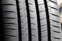 トレッドパターンでは、リブ(タイヤ中央に連なる帯状のブロック)のカドや各部の溝の端が、丸く面取りされている点に注目。前者にはリブ中央の接地圧を高めてウェットグリップ性を高める効果が、後者には制動時のブロックの変形を抑えてフラットな接地面を保つ効果がある。