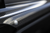 カーボン製のインテリアトリムは、無償オプションとして用意されているアイテム。センターコンソール寄りに、小さな「ALPINA」のエンブレムが備わる。フロアマットにも同様のエンブレムが採用されている。