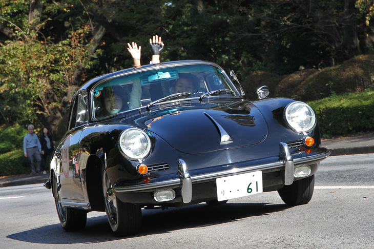 銀座方面に向かったパレードから神宮に戻り、絵画館前への再入場に際して外苑周回路を走る、1961年「ポルシェ356B スーパー90」。