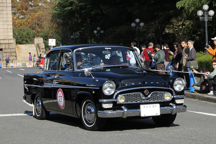 スタート後、公道に向かって絵画館の敷地内を走る「神戸5」のシングルナンバーを付けた1961年「トヨペット・クラウン1900デラックス」。初代クラウンの最終型である。