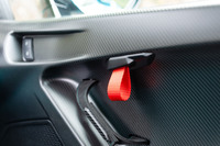 ドアオープナーはベルトループ式。カーボン製の一枚物のドアパネルがド迫力だ。