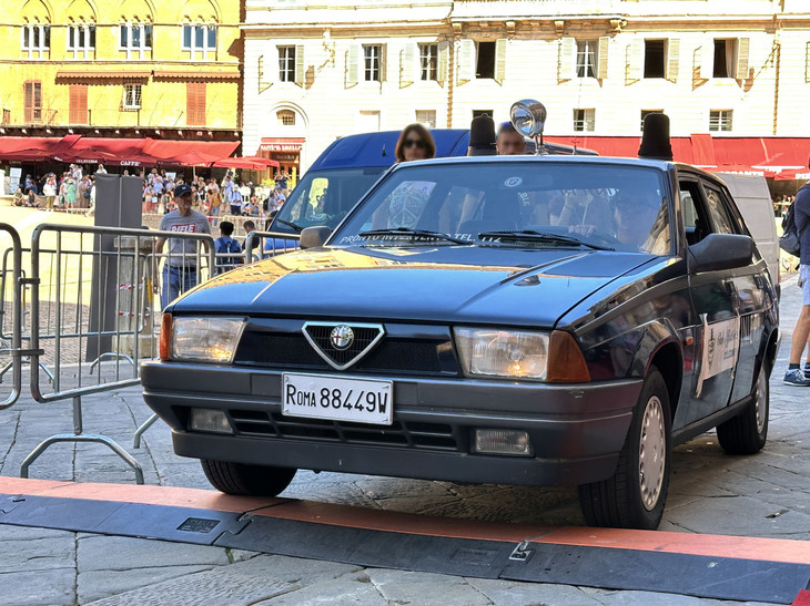 遅れて到着した「アルファ・ロメオ75」。すでに退役したコレクション車両であるため、展示会場に至る公道走行時はCARABINIERIの文字にマスキングを施し、回転灯も黒いカバーで覆う。