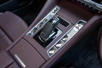 変速機はアイシン製の8段AT「e-EAT8」。シフトセレクターのまわりにはギヨシェ彫り(風)のウィンドウオープナーなどが整然と並べられる。