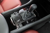 ステアリングホイールからの持ち替えやすさを追求したというシフトセレクター。その後ろのインフォテインメントシステムの操作部も含めて、先代の「アクセラ」よりも前方にレイアウトしている。