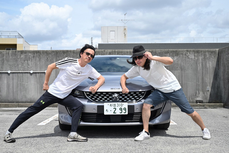 「プジョー508 GT BlueHDi」は、中古車記者歴25年の伊達軍曹(写真右)にも「シルバーの508、正体不明の金持ちに見えます!」と好評だった。ただし軍曹は生え抜きのカーマニアのせいか、マッサージ機能への称賛はなかった。(写真=茂呂幸正)