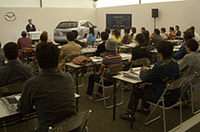 マツダの川崎俊介主査によるプレゼンテーションに聞き入る参加者たち。