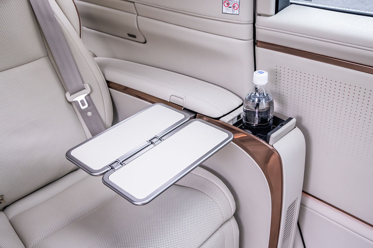 左右ドア側のアームレストに格納式テーブルとカップホルダーを内蔵。テーブルの天板は強度の高いマグネシウム製で、滑り止め/傷つき防止の機能性を有する皮張り仕様となっている。