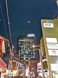 原宿・竹下通りの上空を飛ぶ旅客機。2023年11月撮影。