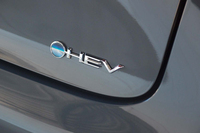 テールゲートに装着された、新しいハイブリッドバッジ。かつてトヨタは、ハイブリッド車を「HV」、プラグインハイブリッド車を「PHV」と称していたが、最近では前者を「HEV」、後者を「PHEV」と称するようになった。