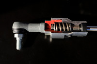 「フレキシブルドロースティフナー」のカット模型。内部のスプリングによってボディーに適度なテンションをかけ、走行中のシャシーのしなりを補正する仕組みだ。